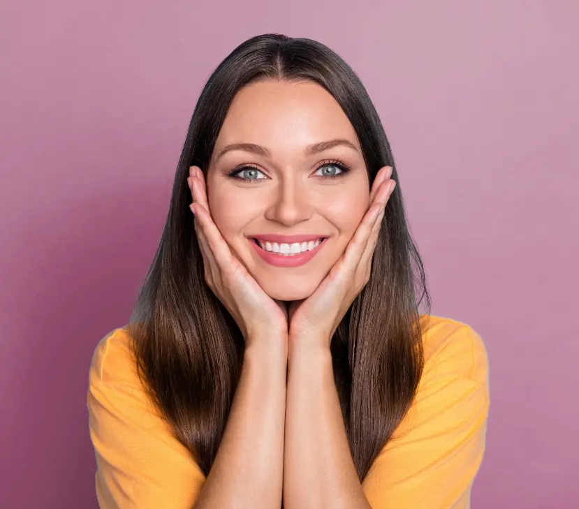 woman smiling with hands on cheeks