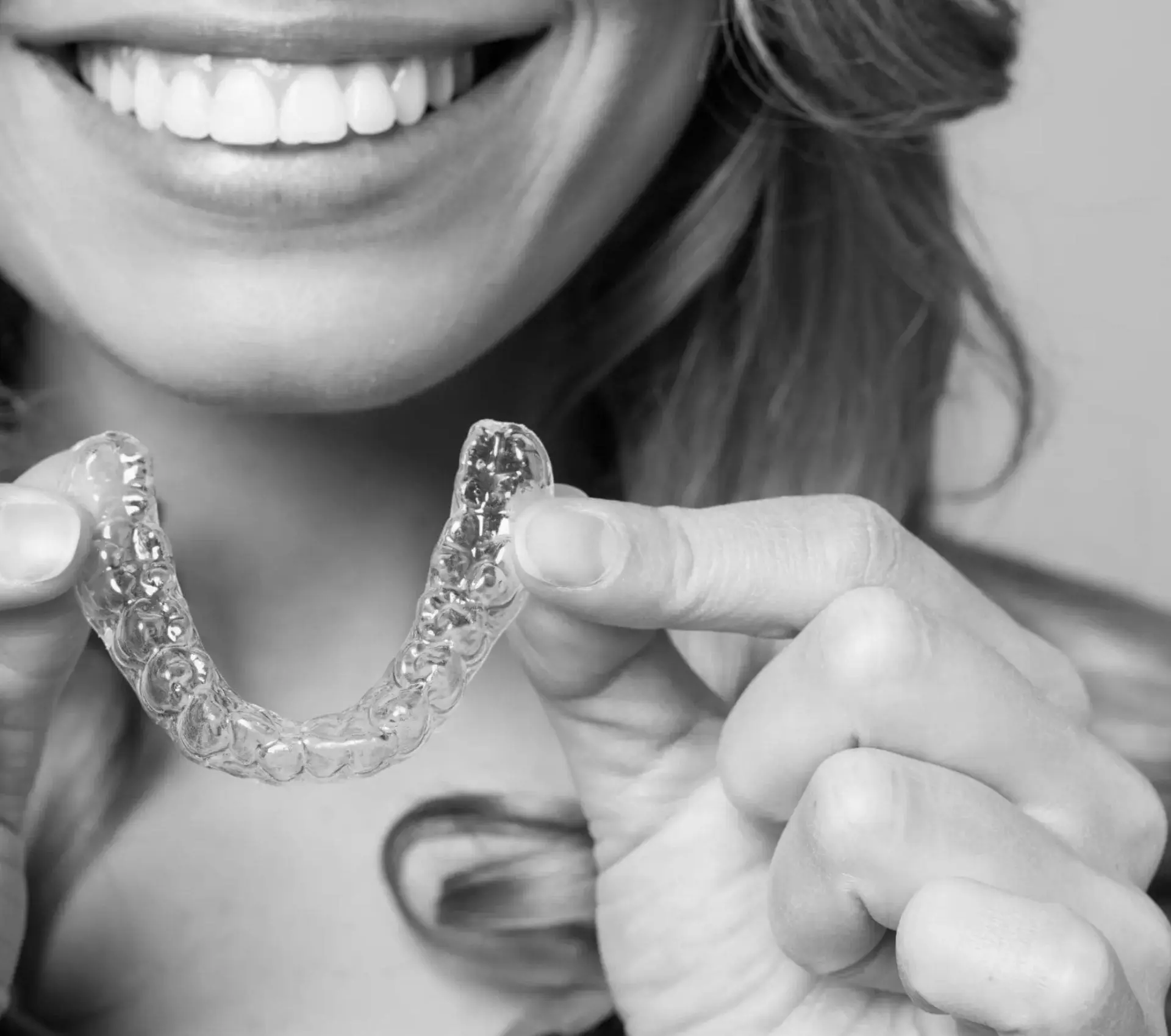 woman smiling holding aligners